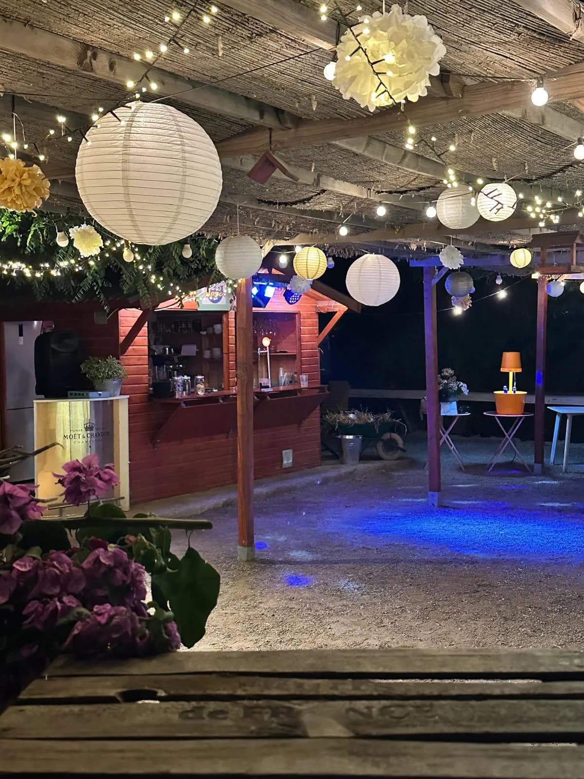 El bar de l'hípica il·luminat amb fanalets durant un esdeveniment al vespre