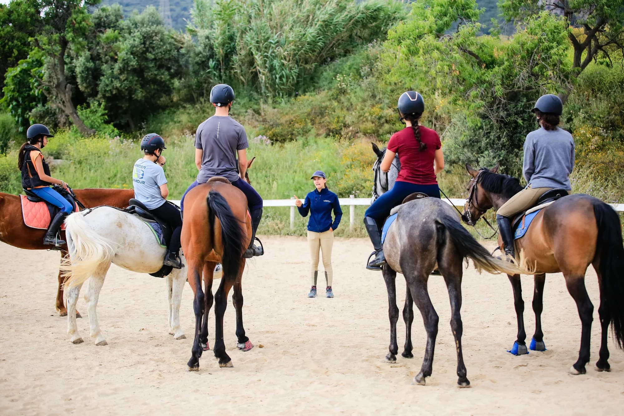 Grup d'alumnes a cavall a la pista durant una classe